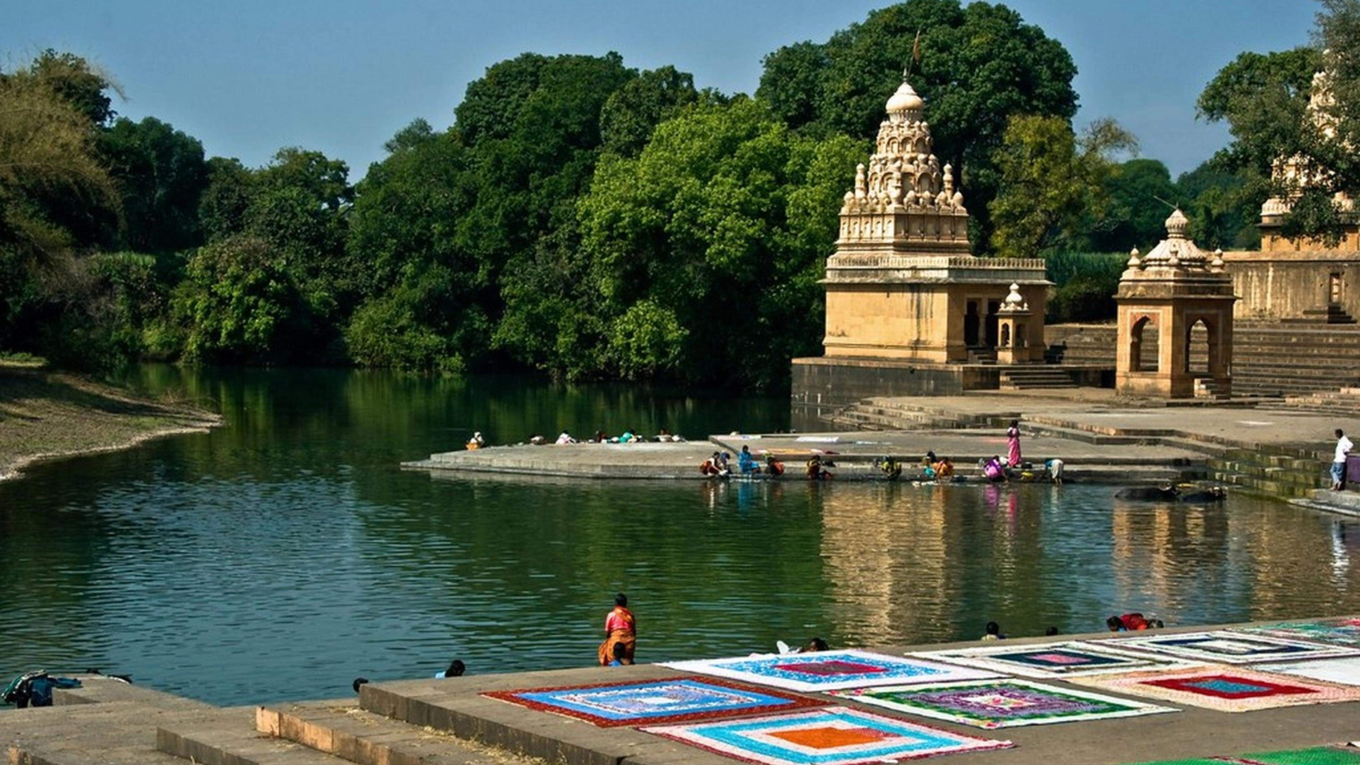 Scenic view of Wai temples by the river, surrounded by lush greenery, located near Ramsukh Resort in Mahabaleshwar.